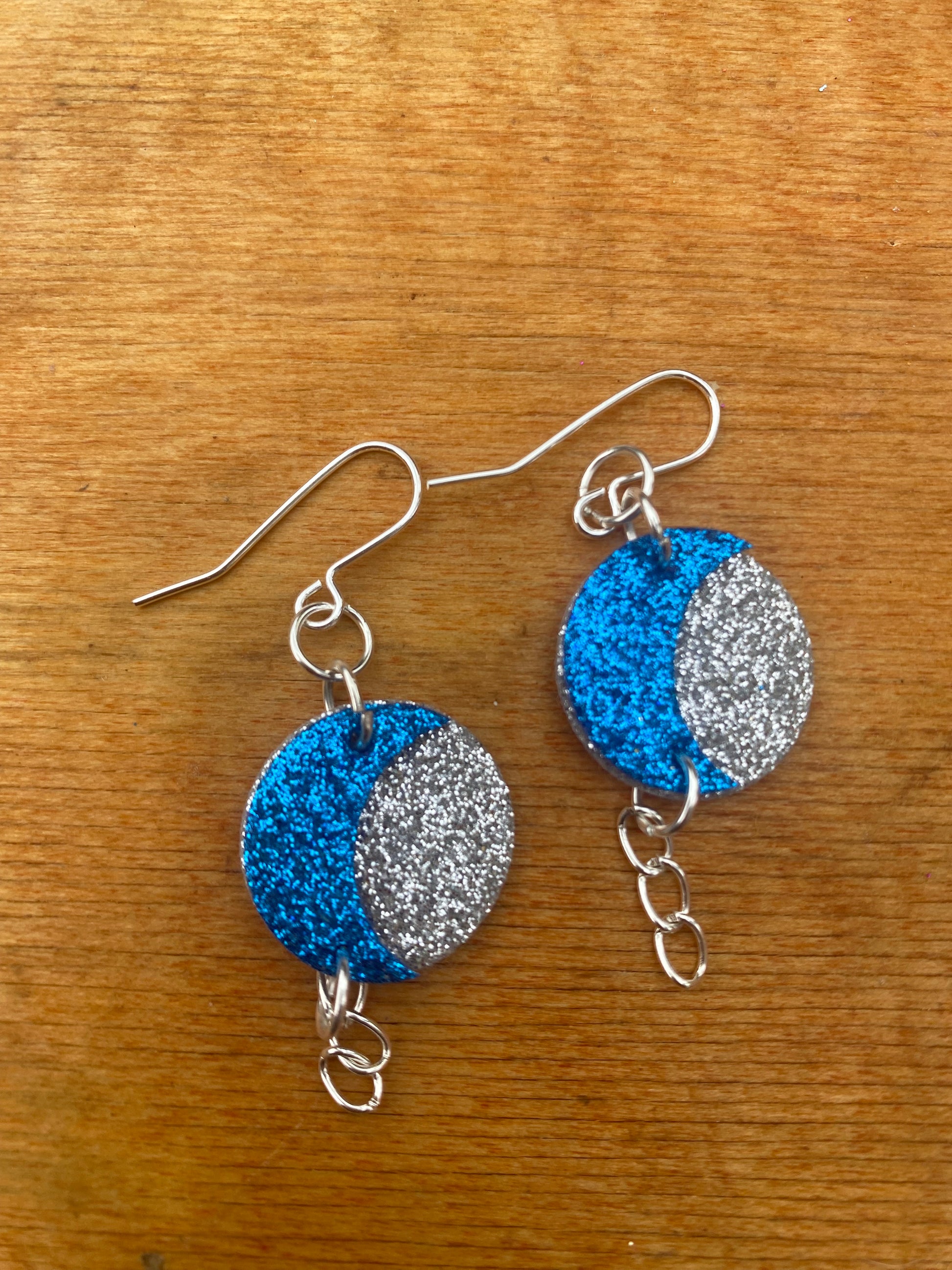 Pair of earrings with blue and silver glittery felt with crescent moon design 
